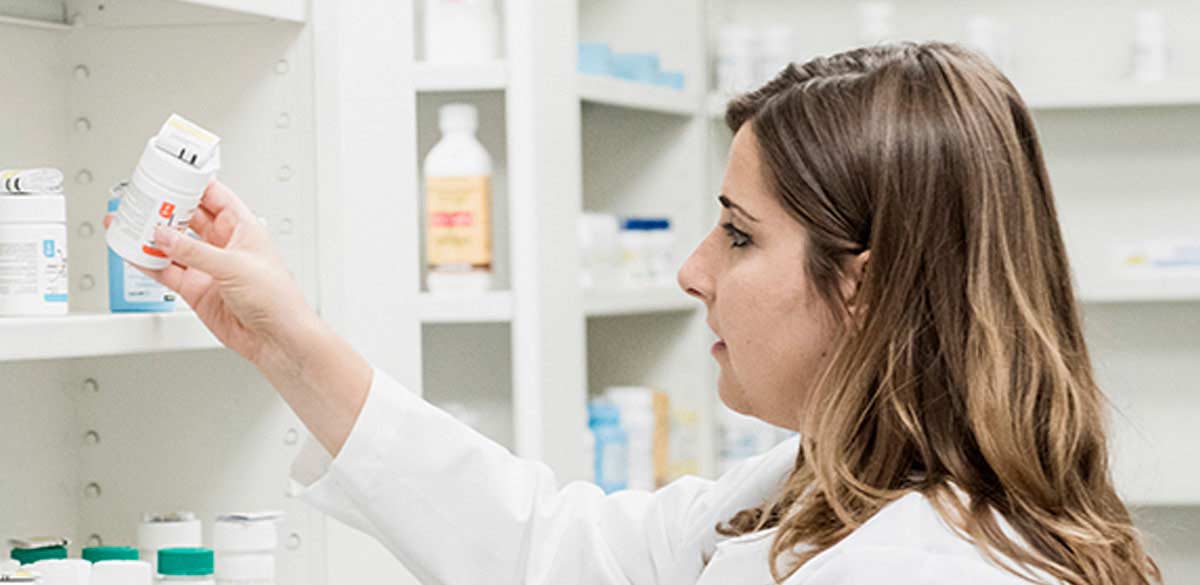 Eine Apothekerin nimmt ein Medikament der Novartis Pharma GmbH aus dem Regal